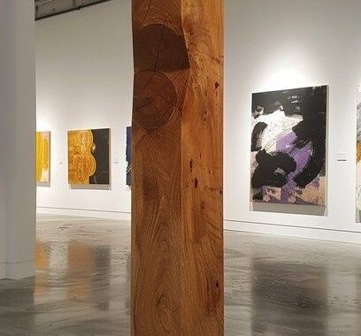 Sculpture en bois monumentale dans une galerie d’art silencieuse