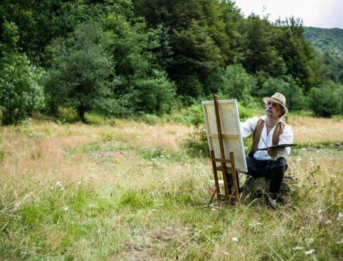Artiste peignant en plein air, face à une forêt et une prairie